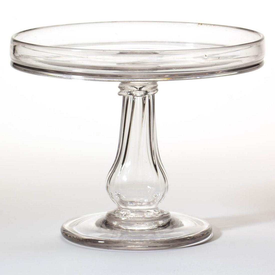 FREE-BLOWN AND PATTERN-MOLDED SALVER / CAKE STAND: FREE-BLOWN AND PATTERN-MOLDED SALVER / CAKE STAND, colorless lead glass, gallery-rim plate raised on a hollow eight-rib baluster-form stem, and a broad, slightly conical foot with rough pontil mark. U
