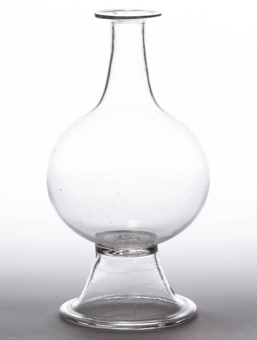 FREE-BLOWN GLASS WATER LENS FOR LIGHTING: FREE-BLOWN GLASS WATER LENS FOR LIGHTING, colorless, baluster form with a flared mouth, applied conical foot with a widened base, rough pontil mark. Maker unverified. First half 19th century. 9" H, 4 