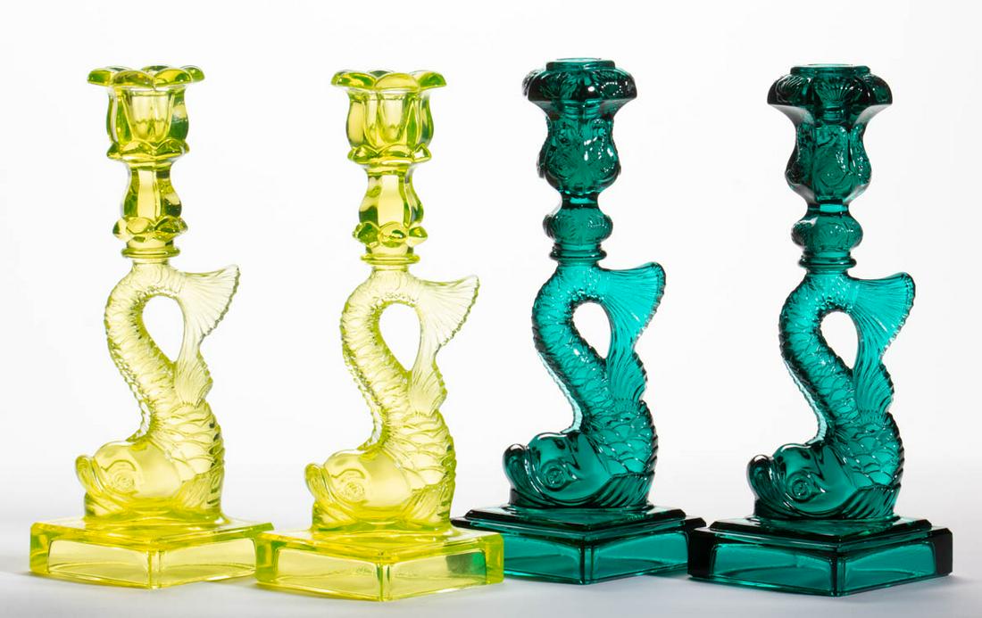 ASSORTED PRESSED REPRODUCTION DOLPHIN-STEM: ASSORTED PRESSED REPRODUCTION DOLPHIN-STEM CANDLESTICKS, LOT OF FOUR, comprising a pair of teal examples with fancy embossed sockets, and a pair of Canary/Vaseline examples with a petal socket, each e