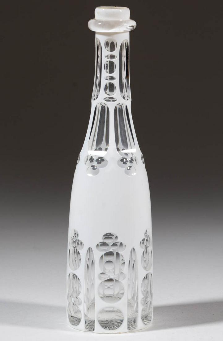 CUT OVERLAY BITTER'S / BARBER'S BOTTLE: CUT OVERLAY BITTER'S / BARBER'S BOTTLE, opaque white to colorless, tall, tapered cylindrical form with various punty, trefoil, and oval cuttings to the neck and base, applied ring below mouth, bases w