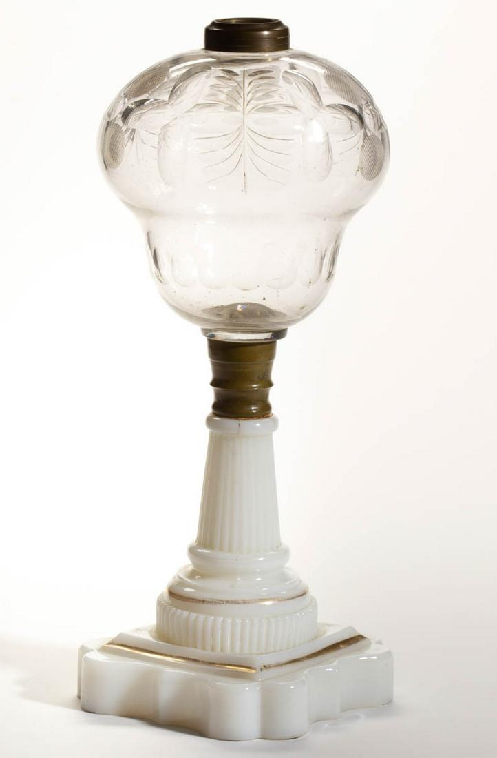 BLOWN AND CUT GLASS KEROSENE STAND LAMP: BLOWN AND CUT GLASS KEROSENE STAND LAMP, colorless font, pyriform font with cut crosses and fern cuts with a lower punty band, brass connector, opaque white Baroque base with gilt decoration, brass fi