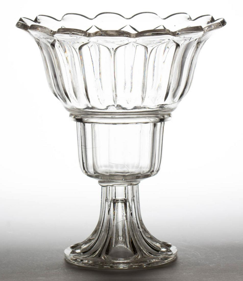 PRESSED ARCHED FLUTE WINE COOLER: PRESSED ARCHED FLUTE WINE COOLER, colorless lead glass, with a deep stepped bowl and 15-scallop rim, raised on an Elongated Loop foot, wafer construction. Boston & Sandwich Glass Co. 1860-1870. 10 3/8