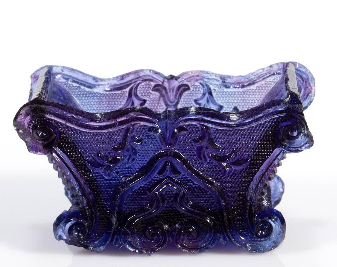 SC-5 GOTHIC ARCH SCROLL PRESSED OPEN SALT: SC-5 GOTHIC ARCH SCROLL PRESSED OPEN SALT, violet and blue mixture, scrolled rim, raised on four scrolled feet. Very rare. Possibly Boston & Sandwich Glass Co. 1835-1850. 1 3/4" H, 1 5/8" x 3 1/4". Ha