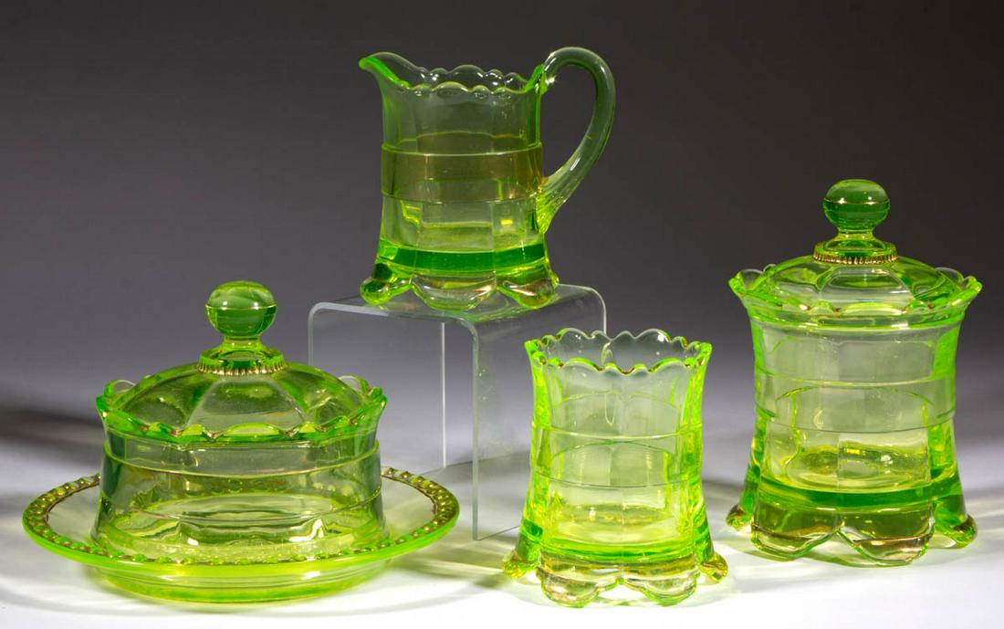 RIVERSIDE NO. 500 / RANSON FOUR-PIECE TABLE SET: RIVERSIDE NO. 500 / RANSON FOUR-PIECE TABLE SET, Vaseline (reacts under black light) with gilt decoration, comprising a covered butter dish, covered sugar bowl, creamer, and spooner. Riverside Glass W