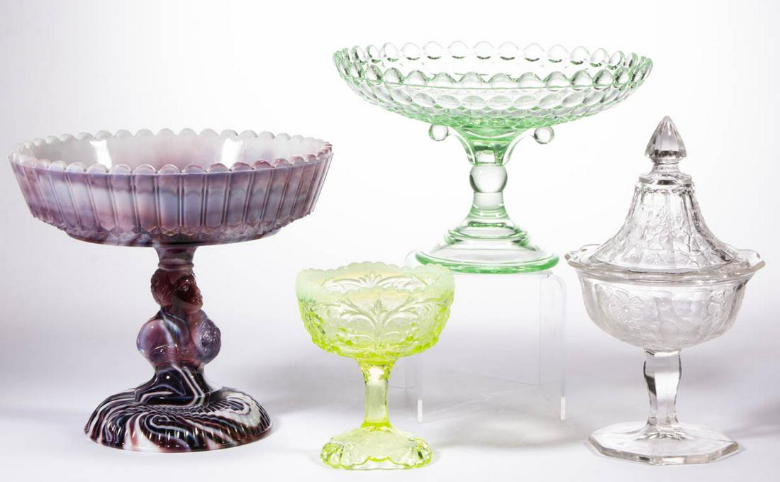 ASSORTED PRESSED GLASS ARTICLES, LOT OF FOUR: ASSORTED PRESSED GLASS ARTICLES, LOT OF FOUR, comprising a colorless Northwood Singing Birds sweetmeat compote, a purple slag Jenny Lind compote, an apple green (reacts under black light) Adams Thousa
