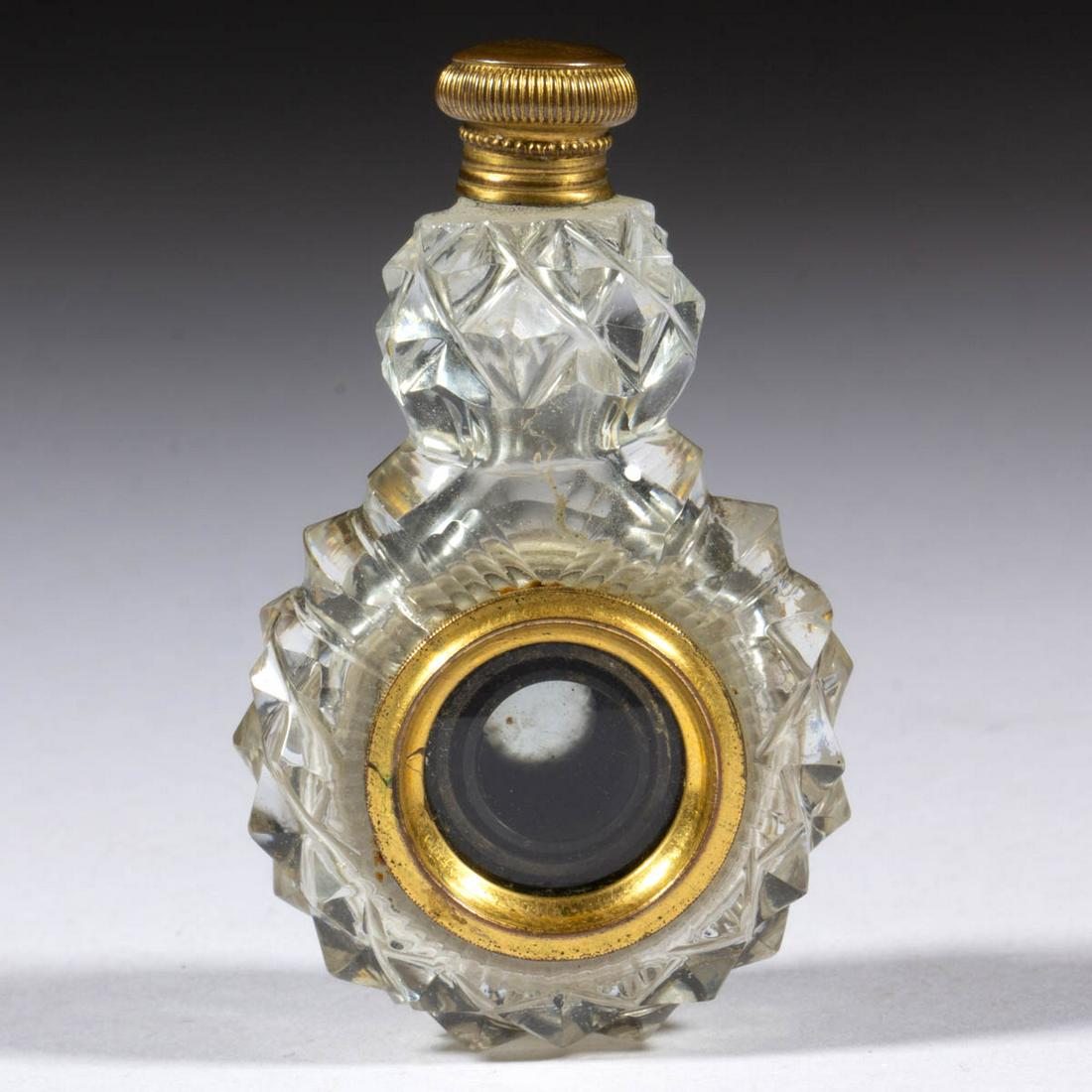 CUT GLASS AND BRASS PERFUME BOTTLE WITH MONOCULAR: CUT GLASS AND BRASS PERFUME BOTTLE WITH MONOCULAR, colorless, globular base with a knop neck with a central extending monocular, diamond pattern, brass lid. Maker unverified. 19th century. 2 5/8" H. E