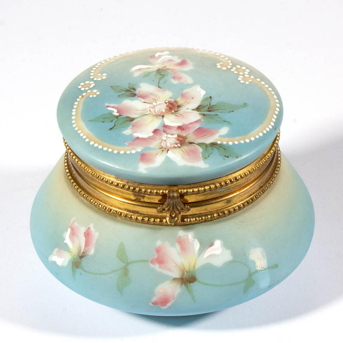 WAVE CREST NAKARA ENAMEL-DECORATED DRESSER BOX: WAVE CREST NAKARA ENAMEL-DECORATED DRESSER BOX, opaque white with blue ground and polychrome-enamel decoration, tapered body, original brass mount, floral decoration, signed to the underside, "C. F. M