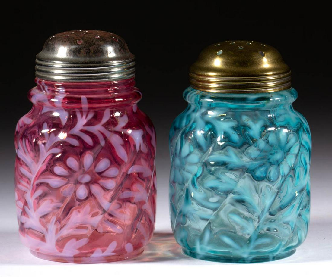 DAISY AND FERN - PARIAN SWIRL SUGAR SHAKERS, LOT OF TWO: DAISY AND FERN - PARIAN SWIRL SUGAR SHAKERS, LOT OF TWO, blue opalescent and cranberry opalescent, each having a period lid. Northwood Glass Co. Circa 1895. 4 1/2" H. Cranberry having a couple of chip