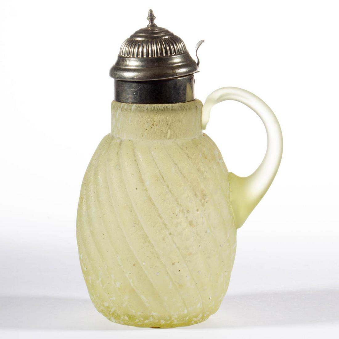 REVERSE SWIRL - GRANITEWARE SYRUP PITCHER: REVERSE SWIRL - GRANITEWARE SYRUP PITCHER, Vaseline (reacts under black light) with opal frit decoration, with applied handle, period lid. Buckeye Glass Co. or Model Flint Co. 1888-1902. 7" HOA. Undam