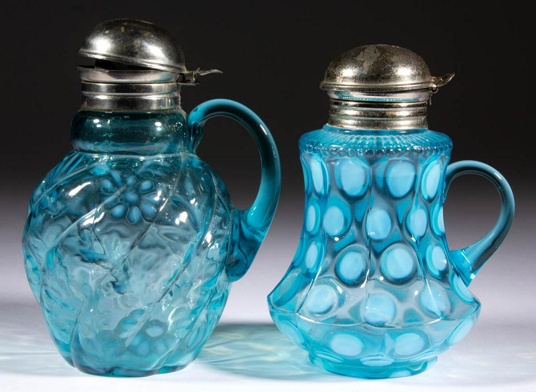 ASSORTED OPALESCENT GLASS SYRUP PITCHERS, LOT OF TWO: ASSORTED OPALESCENT GLASS SYRUP PITCHERS, LOT OF TWO, blue opalescent, comprising a Coinspot nine-panel and a swirled Daisy and Fern, each having a period lid. Various makers. Late 19th/early 20th cen