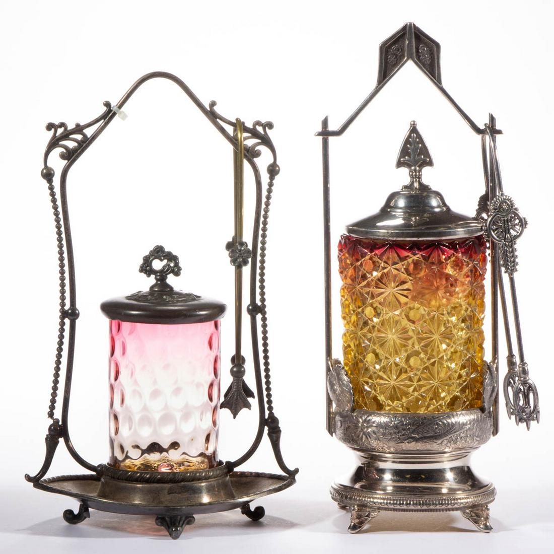 ASSORTED AMBERINA GLASS PICKLE CASTERS, LOT OF TWO: ASSORTED AMBERINA GLASS PICKLE CASTERS, LOT OF TWO, comprising a Spot-Optic, and a Daisy and Button example, each fitted into a quadruple-plated stand with a cover and tongs. Various makers. Fourth qu