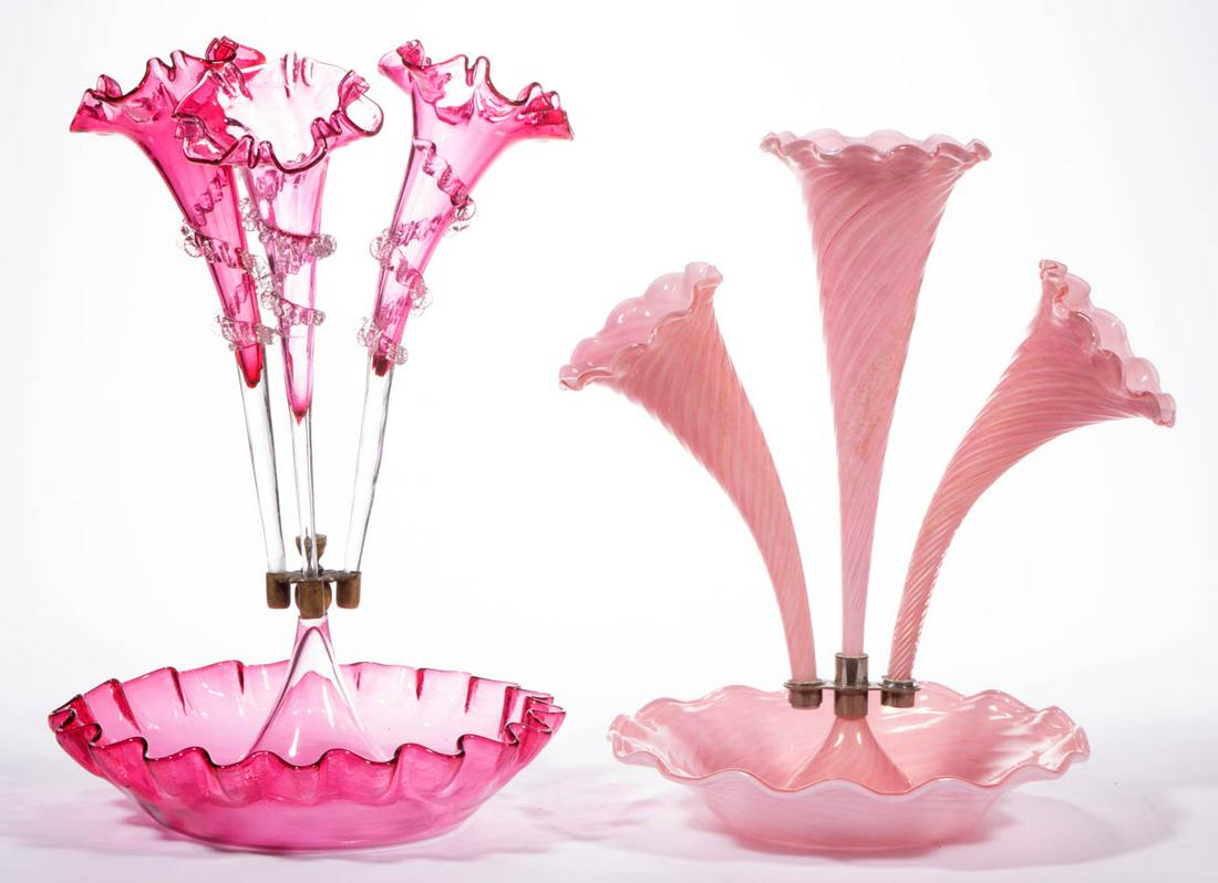 ASSORTED VICTORIAN GLASS EPERGNES, LOT OF TWO: ASSORTED VICTORIAN GLASS EPERGNES, LOT OF TWO, comprising a cased cranberry example having three vases with each having applied colorless rigaree, and a pink swirled example with aventurine decoration