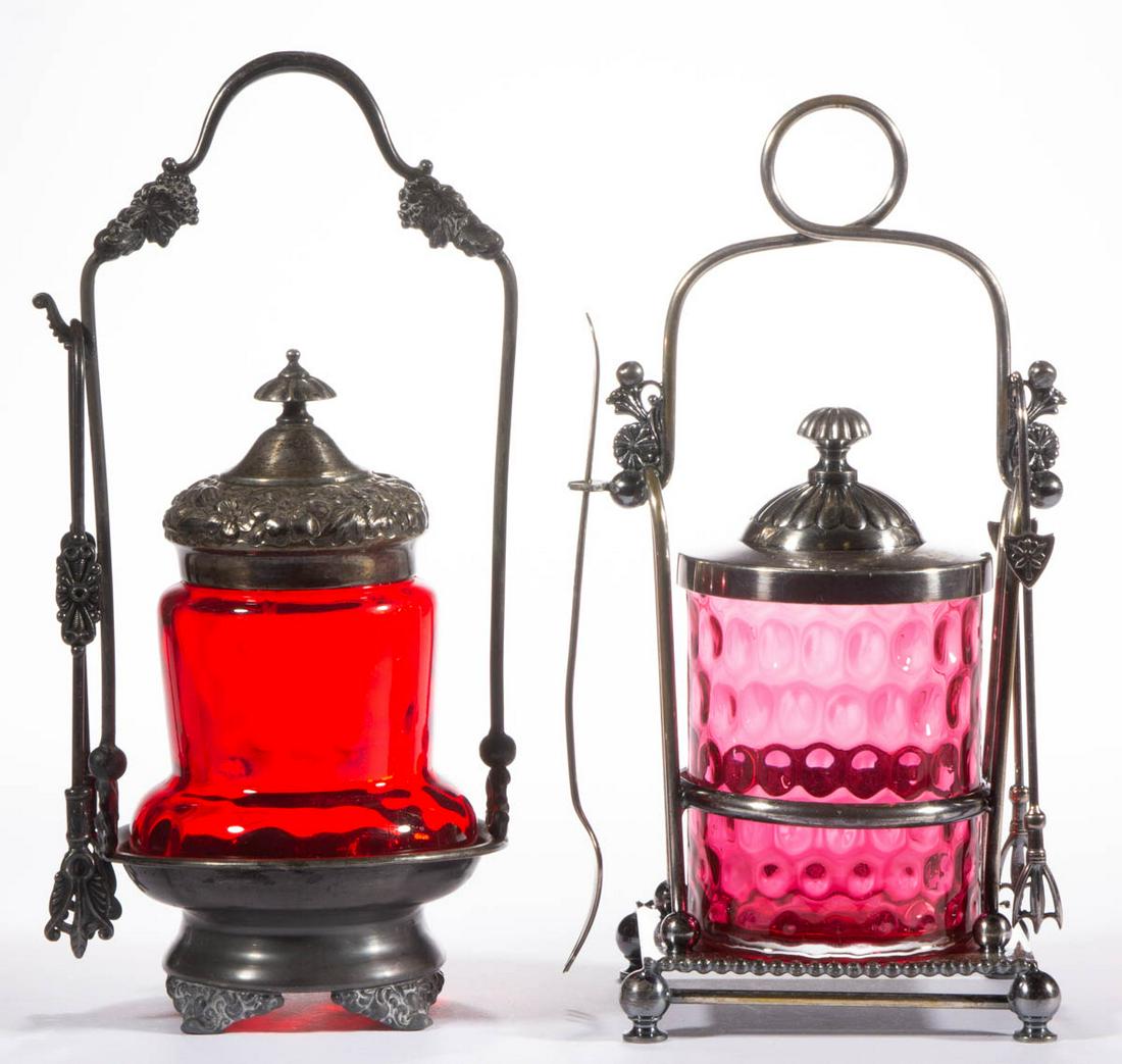ASSORTED VICTORIAN SPOT-OPTIC GLASS PICKLE CASTERS, LOT: ASSORTED VICTORIAN SPOT-OPTIC GLASS PICKLE CASTERS, LOT OF TWO, cranberry and ruby, comprising a cylindrical form and an acorn form, each fitted into a quadruple-plated stand with a cover and tongs. V