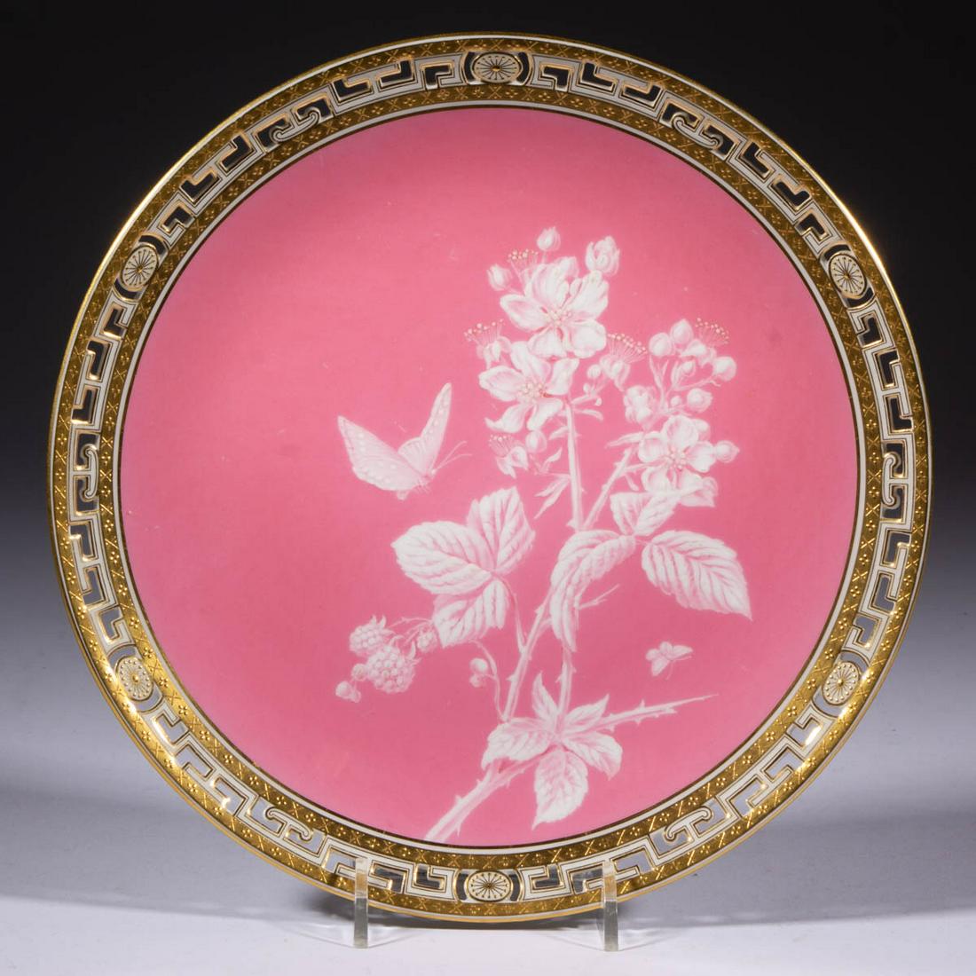 ENGLISH MINTONS PINK-ENAMELED PORCELAIN RETICULATED: ENGLISH MINTONS PINK-ENAMELED PORCELAIN RETICULATED PLATE, featuring Limoges-style white hand-painted design featuring a blackberry/raspberry flowering branch with butterfly and gilt geometric Greek k