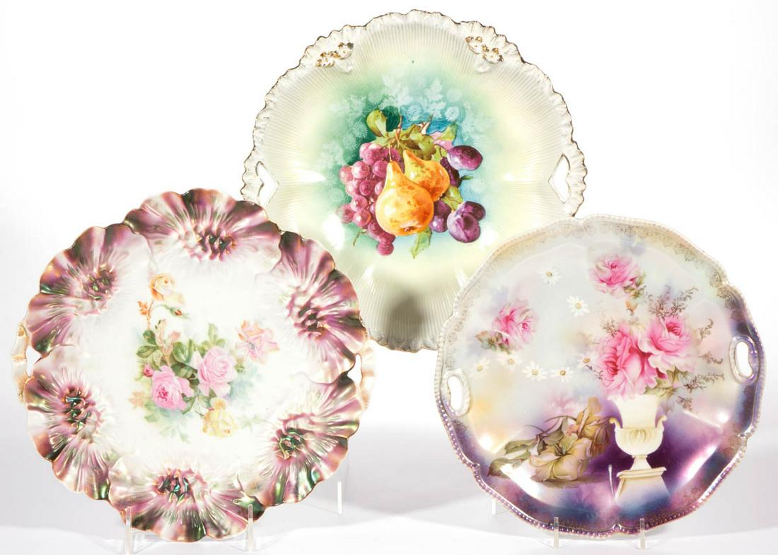 R.S. PRUSSIA PORCELAIN CAKE PLATES, LOT OF THREE: R.S. PRUSSIA PORCELAIN CAKE PLATES, LOT OF THREE, comprising two with satin finish including a Mold 31 example having rose transfer motif and one Mold 300 example with image of a rose bouquet in an ur