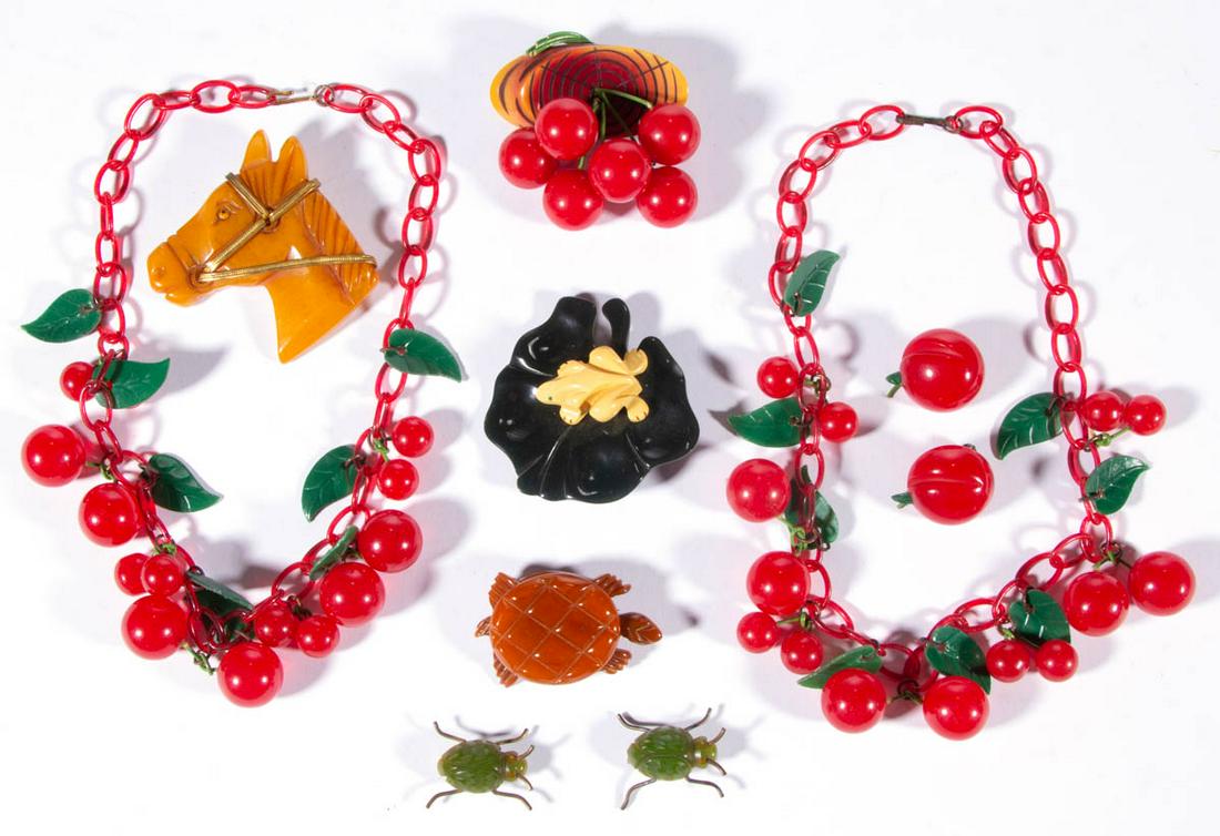 VINTAGE FIGURAL BAKELITE JEWELRY, LOT OF TEN PIECES: VINTAGE FIGURAL BAKELITE JEWELRY, LOT OF TEN PIECES, comprising two necklaces consisting of Bakelite cherries with plastic/celluloid chains and leaves, a pair of apple clip-on earrings, a brooch with 