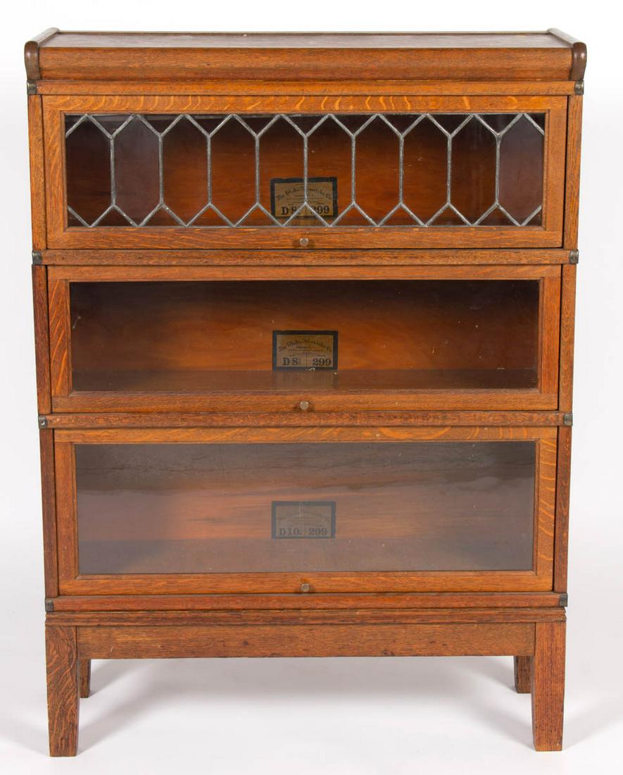 GLOBE-WERNICKE CO., CINCINNATI, OHIO OAK THREE-STACK: GLOBE-WERNICKE CO., CINCINNATI, OHIO OAK THREE-STACK BOOK CASE, featuring leaded glass window, retains original label "D- 8 1/2 / Grade 299". Old surface with warm color. First quarter 20th century. 4