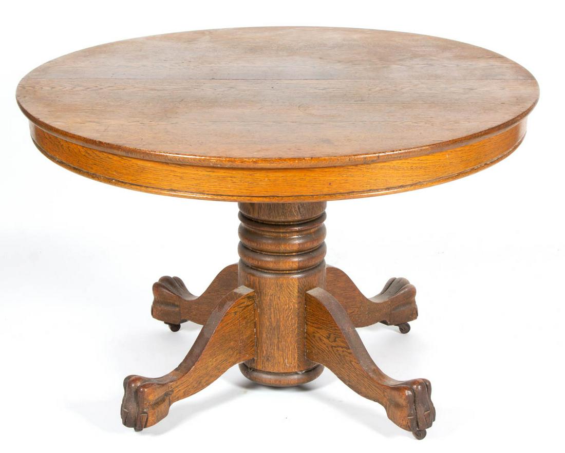 AMERICAN OAK DINING TABLE: AMERICAN OAK DINING TABLE, featuring carved paw feet, with two additional leaves. Old refinished surface with warm color. Late 19th/early 20th century. 29" H, 45" D top.Very good overall condition, wi