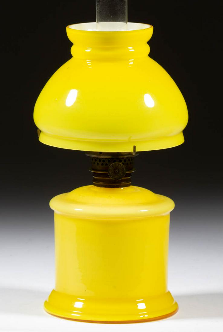 CASED GLASS MINIATURE LAMP: CASED GLASS MINIATURE LAMP, cased lemon yellow, cylinder-form font with wide concave medial band, matching decorated umbrella-form shade, period collar. Fitted with a Plume & Atwood Nutmeg burner, col