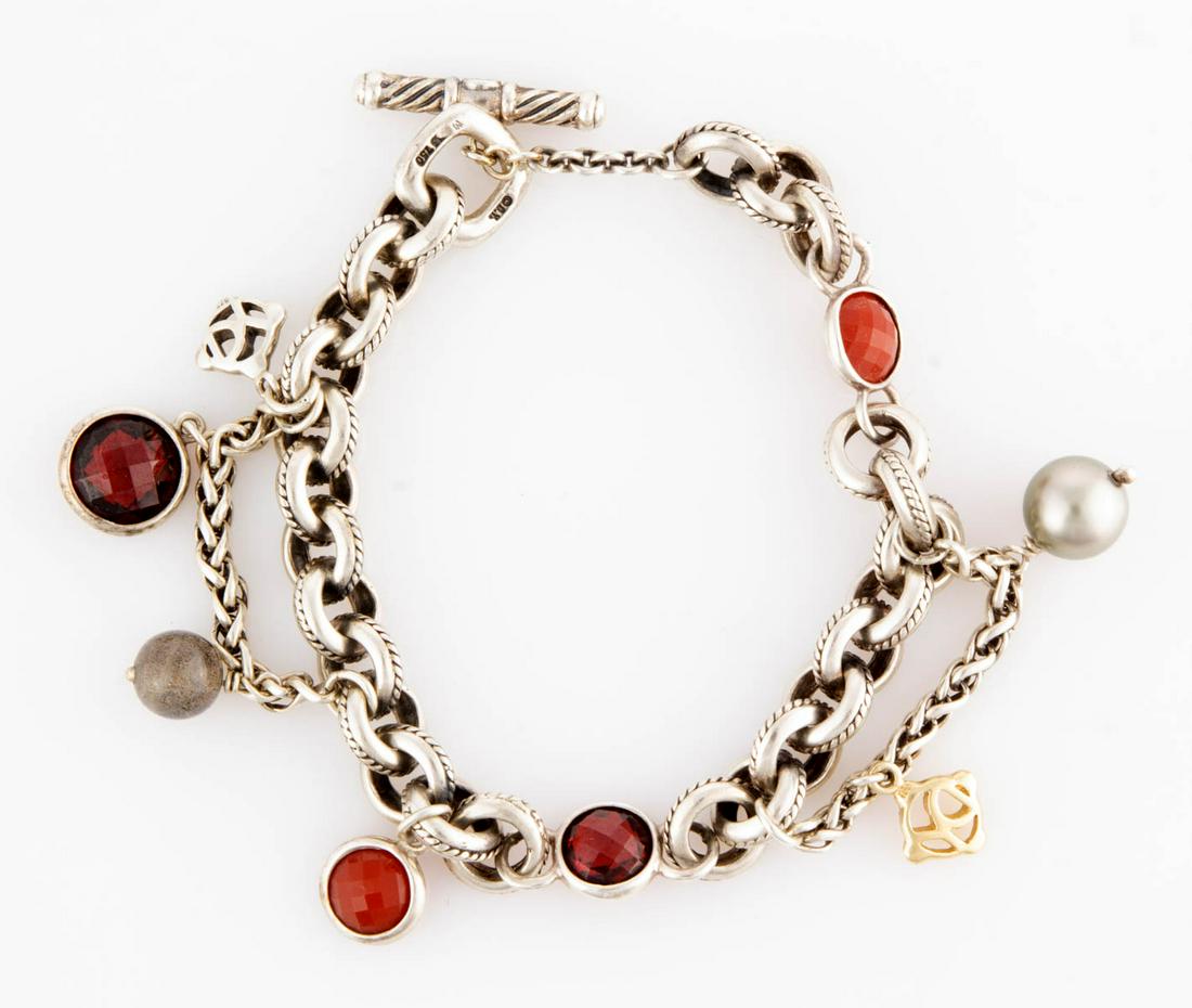 DAVID YURMAN STERLING SILVER AND GEMSTONE CHARM: DAVID YURMAN STERLING SILVER AND GEMSTONE CHARM BRACELET, cable-designed round links with toggle clasp having two faceted garnet and carnelian stone links and two wheat chain extension, featuring six 