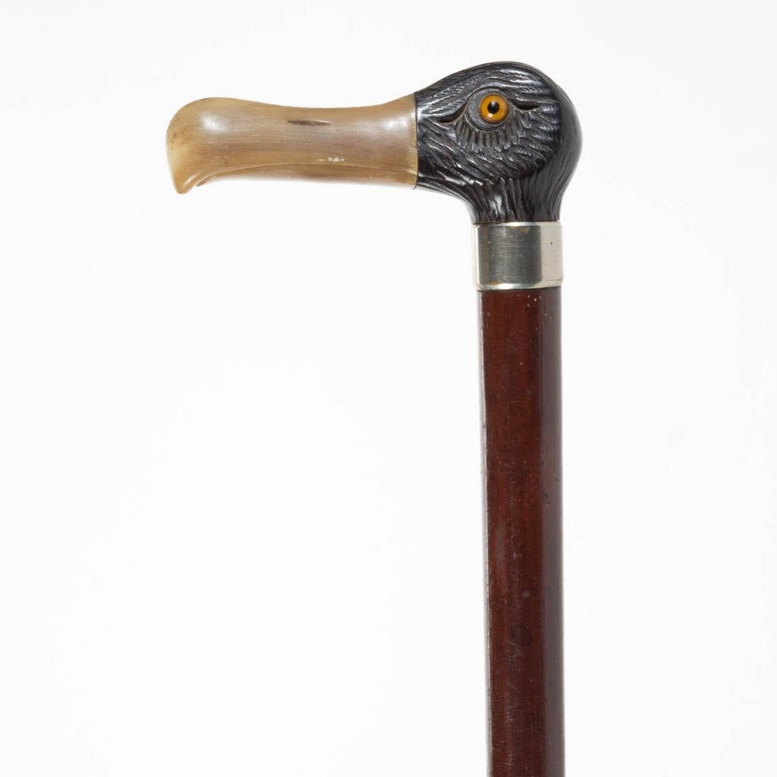 ANTIQUE FIGURAL CANE / WALKING STICK: ANTIQUE FIGURAL CANE / WALKING STICK, carved ebony wood bird head with inset glass eyes and applied carved horn beak, on a plain wooden shaft fitted with metal ferrule. Late 19th/early 20th century. 3