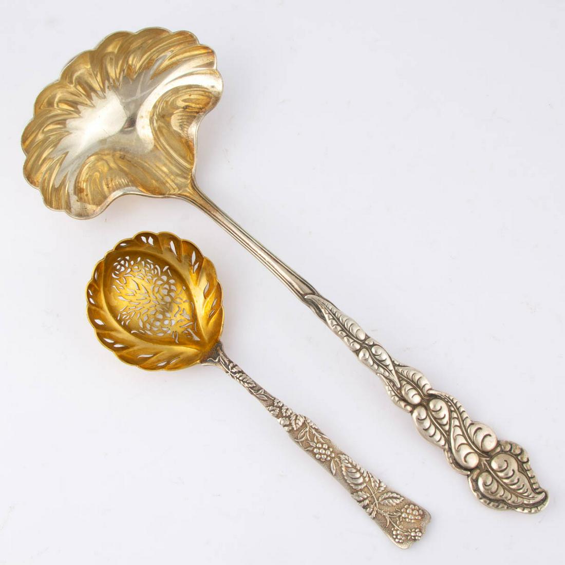 TIFFANY & CO. STERLING SILVER SERVING UTENSILS, LOT OF: TIFFANY & CO. STERLING SILVER SERVING UTENSILS, LOT OF TWO, comprising an "Ailanthus" soup ladle with a gold-washed shell bowl and engraved "ALC" initials to back of handle, and a "Vine" sugar sifter