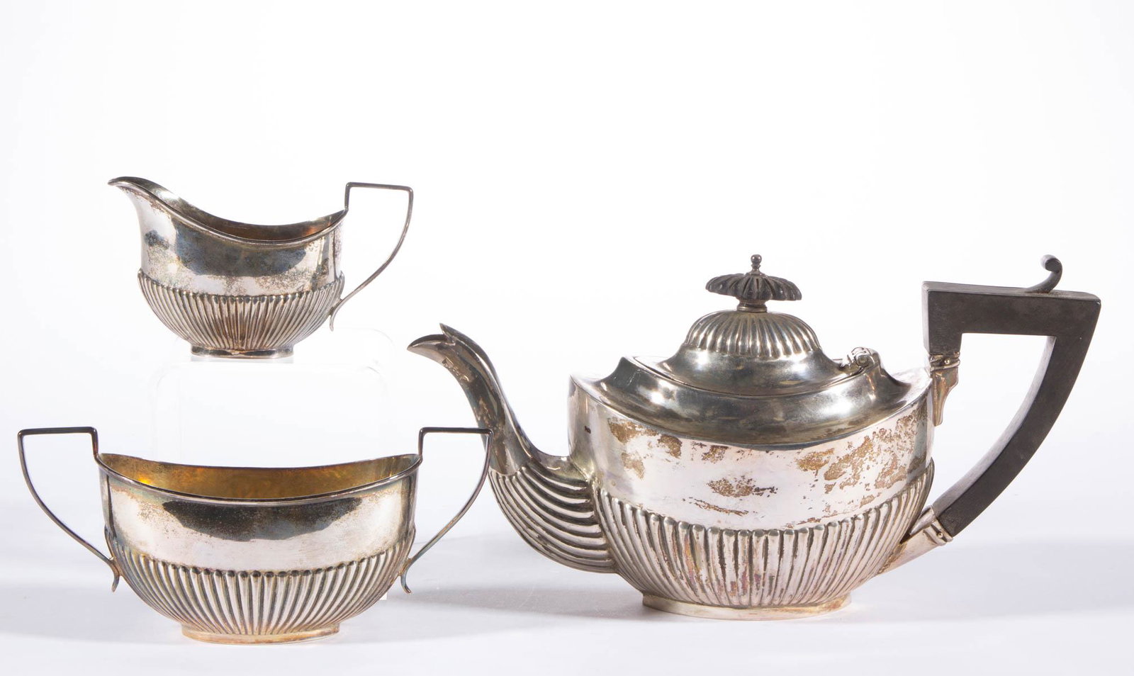ENGLISH NEOCLASSICAL-STYLE STERLING SILVER ASSEMBLED: ENGLISH NEOCLASSICAL-STYLE STERLING SILVER ASSEMBLED THREE-PIECE BREAKFAST / INDIVIDUAL TEA SERVICE, comprising a teapot, a creamer, and an open sugar, each small in size having ovoid form with fluted