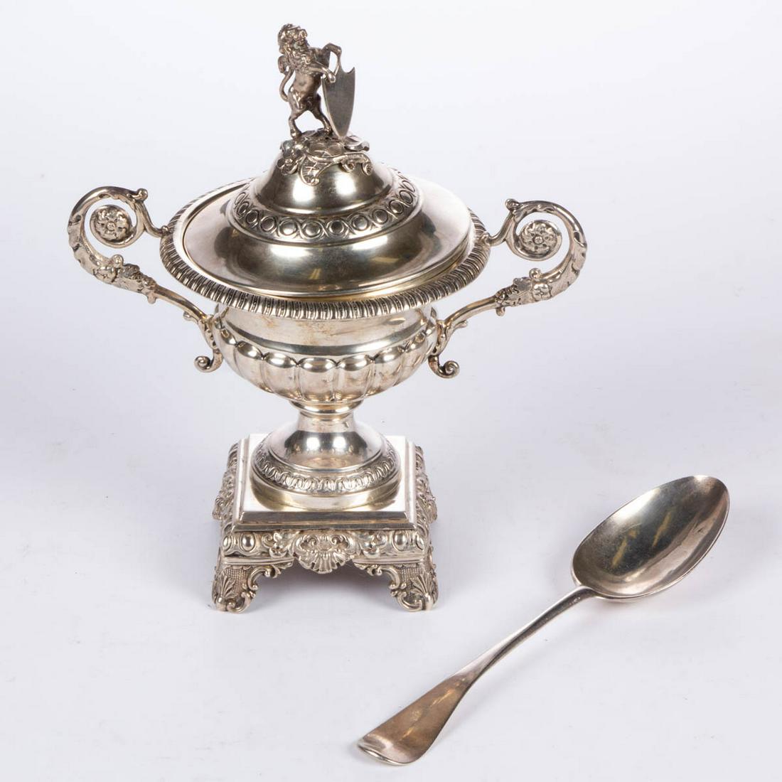 CONTINENTAL 0.800 SILVER COVERED SUGAR: CONTINENTAL 0.800 SILVER COVERED SUGAR, urn-form well with gadroon rim, fluted sides, and two foliate scrolled handles, having a square-form base on four feet with shell, leaf, and scrolled motifs, co