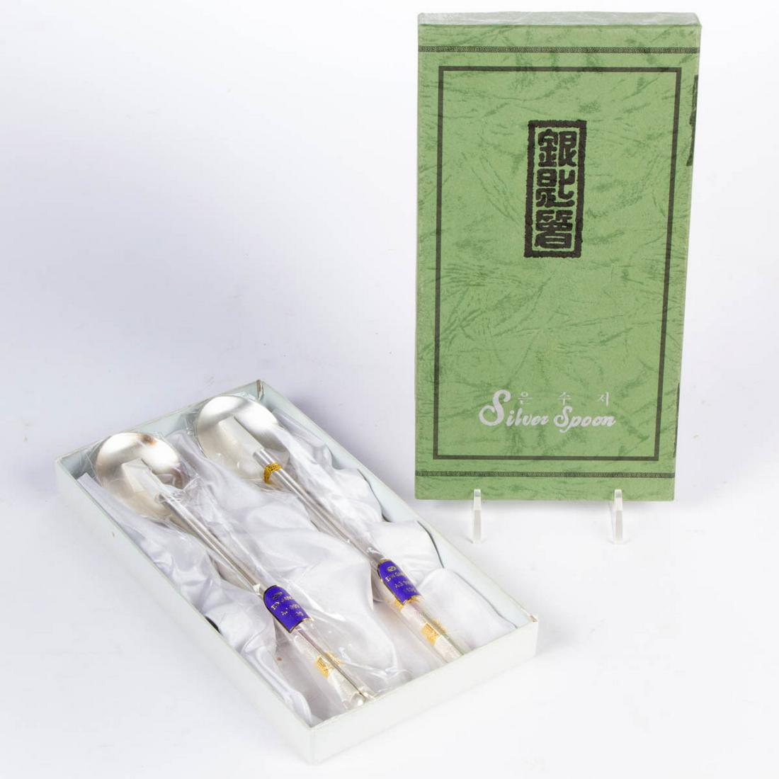 KOREAN FINE SILVER SIX-PIECE CHOPSTICK AND SPOON SET: KOREAN FINE SILVER SIX-PIECE CHOPSTICK AND SPOON SET, comprising two spoons and two pairs of chopsticks, each having patterned handle with diamond-form accents and gold-plated writing, including origi