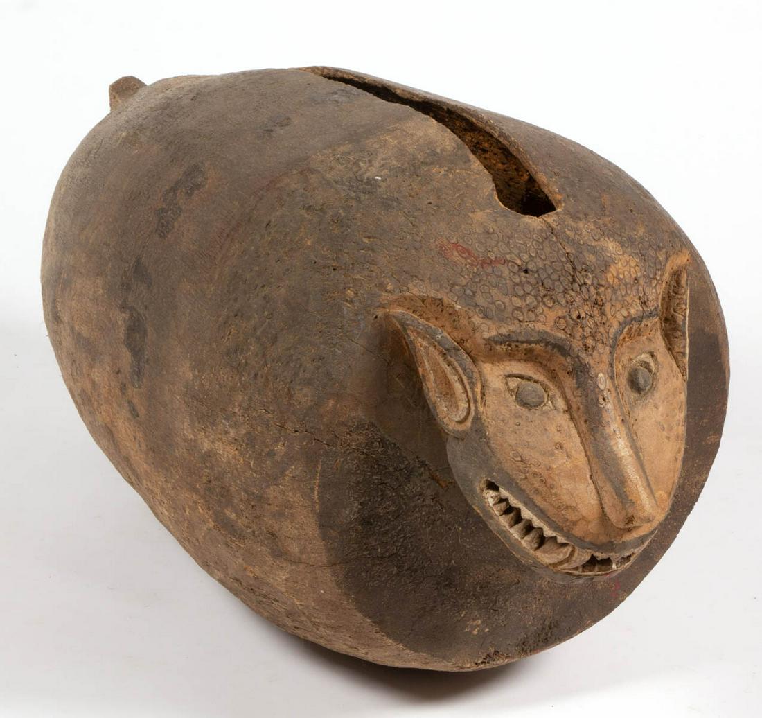 LARGE AFRICAN CARVED SLIT DRUM: LARGE AFRICAN CARVED SLIT DRUM, possibly depicting a boar, hollow, with likely original polychrome-painted face. 20th century. 42" LOA. Very good overall condition, scattered minor to heavy areas of l