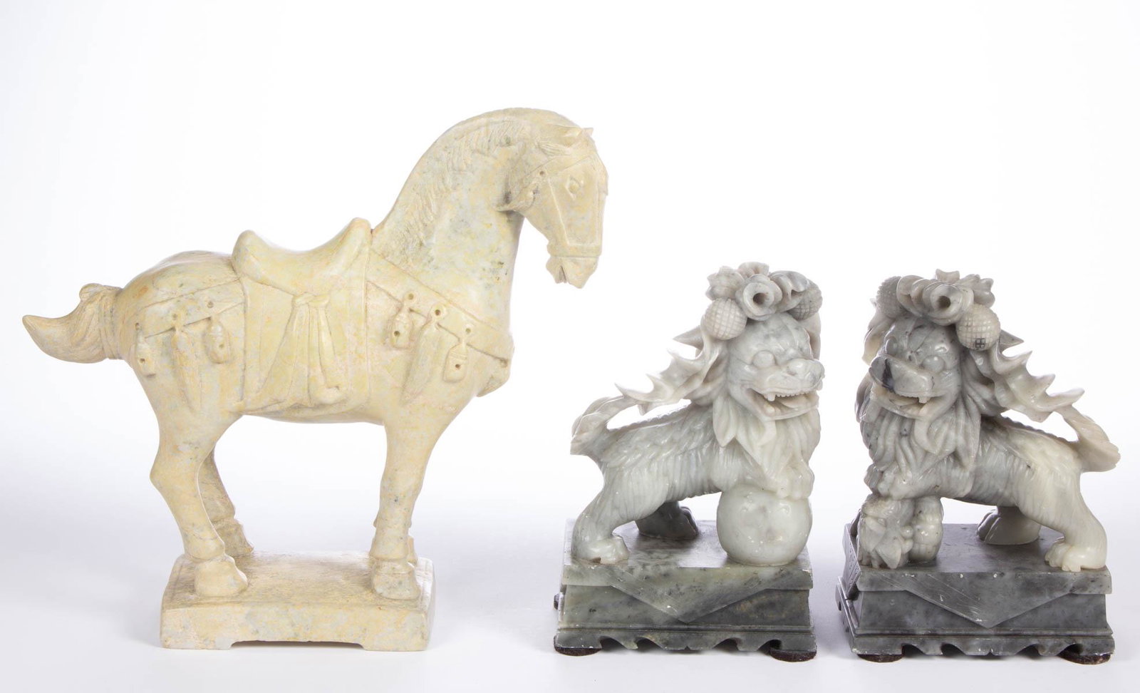 CHINESE CARVED STONE FIGURES, LOT OF THREE: CHINESE CARVED STONE FIGURES, LOT OF THREE, comprising a pair of foo dogs on rectangular bases, and a Ming-style warrior's horse. 20th century. 8 1/4" and 11 1/2" HOA. Excellent condition, dogs with m