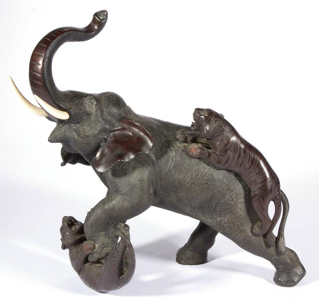 JAPANESE MEIJI PERIOD BRONZE FIGURE OF AN ELEPHANT: JAPANESE MEIJI PERIOD BRONZE FIGURE OF AN ELEPHANT, finely detailed example featuring a pachyderm with bone tusks being attacked by two tigers, signed to belly, retaining an excellent undisturbed pati