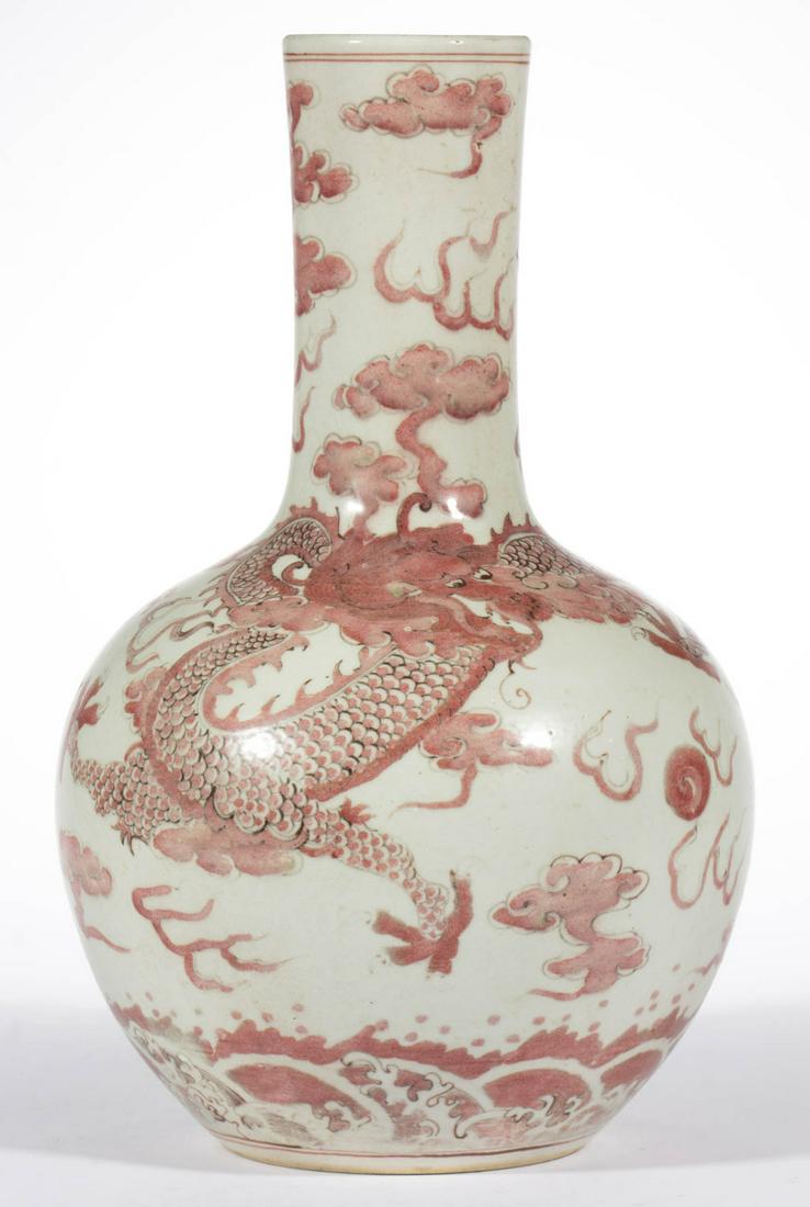 CHINESE EXPORT PORCELAIN VASE: CHINESE EXPORT PORCELAIN VASE, bottle form, featuring a red dragon and a Fenghuang bird chasing a flaming pearl. Having blue four-character Kangxi Nian Zhi mark to underside. 20th century. 12 7/8" HOA