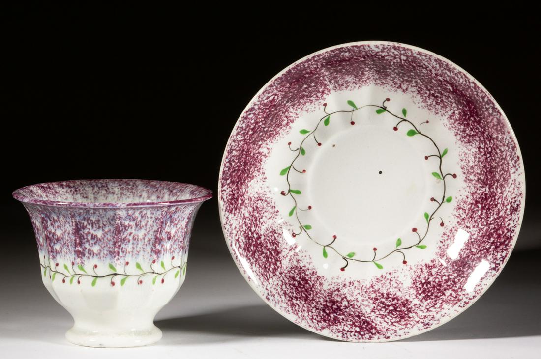ENGLISH SPATTERWARE HOLLY BERRY CERAMIC CUP AND SAUCER: ENGLISH SPATTERWARE HOLLY BERRY CERAMIC CUP AND SAUCER, each featuring a polychrome hand-painted vine with small berries and purple/mulberry-sponged border. Saucer having impressed rosette to undersid