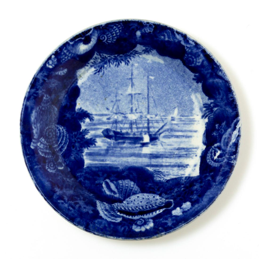 STAFFORDSHIRE BOAT MOTIF TRANSFER-PRINTED CERAMIC CUP: STAFFORDSHIRE BOAT MOTIF TRANSFER-PRINTED CERAMIC CUP PLATE, featuring an anchored tall-masted ship or frigate with sails lowered, irregular shell border with rounded shoulder rim. Impressed eagle and