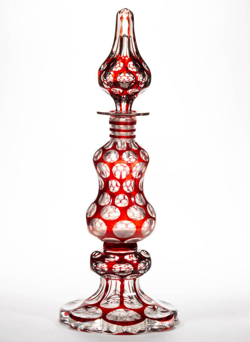 CUT-OVERLAY PUNTY LARGE COLOGNE BOTTLE: CUT-OVERLAY PUNTY LARGE COLOGNE BOTTLE, ruby to colorless, large gourd-form stem featuring eight rows of punty cuts, raised on a complex eight-scallop foot with a single-knop standard, matching steepl