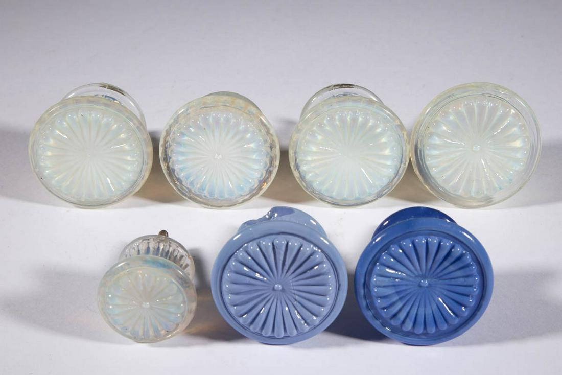 PRESSED ROSETTE GLASS FURNITURE KNOBS, LOT OF SEVEN: PRESSED ROSETTE GLASS FURNITURE KNOBS, LOT OF SEVEN, comprising two opaque powder blue, and five fiery opalescent examples with one being of a diminutive size, each having a metal shank. Probably New 