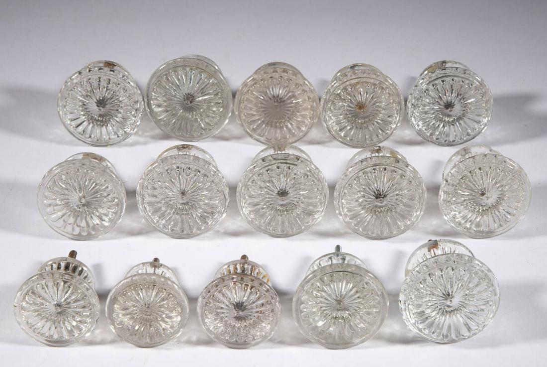 PRESSED GLASS FURNITURE KNOBS, LOT OF 15: PRESSED GLASS FURNITURE KNOBS, LOT OF 15, colorless, comprising ten large-sized and five small-sized examples, each having a reeded pattern with a central button and ribbed sides, eight having a perio