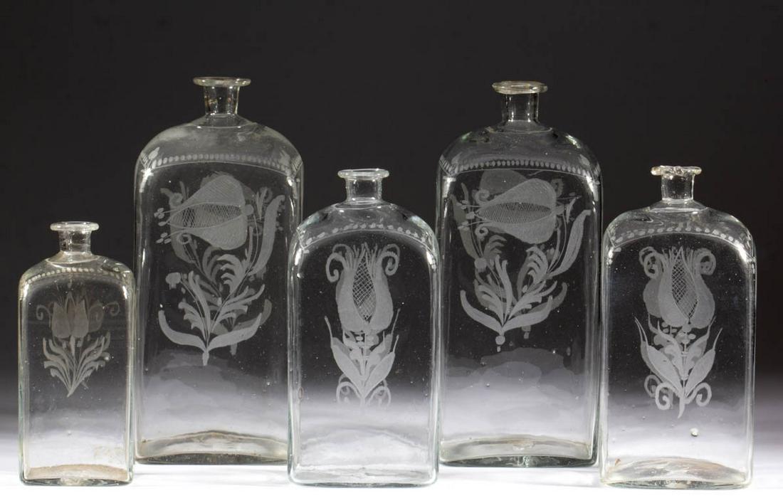 HALF-POST BLOWN AND ENGRAVED CASE BOTTLES, LOT OF FIVE: HALF-POST BLOWN AND ENGRAVED CASE BOTTLES, LOT OF FIVE, colorless, each of rectangular form example with so-called Steigel tulip decoration and rough pontil mark. Late 18th century. 8 1/2" to 11 1/4" 