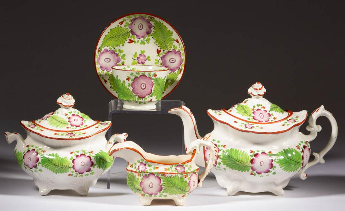 ENGLISH GAUDY FLORAL MOTIF CERAMIC FIVE-PIECE TEA SET: ENGLISH GAUDY FLORAL MOTIF CERAMIC FIVE-PIECE TEA SET, each featuring bold flower and leaf designs with red-banded rims, comprising a teapot, a covered sugar, a creamer, and a cup and saucer set. Mark