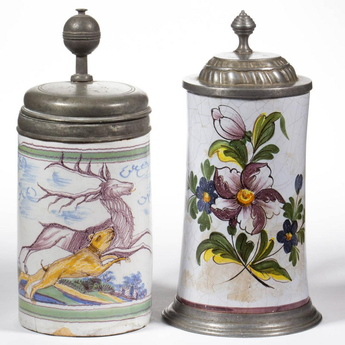 DUTCH DELFT TIN-GLAZED EARTHENWARE TANKARDS, LOT OF TWO: DUTCH DELFT TIN-GLAZED EARTHENWARE TANKARDS, LOT OF TWO, each of cylindrical form with pewter hinged lids and featuring polychrome hand-painted designs, comprising one example featuring a leaping dog 