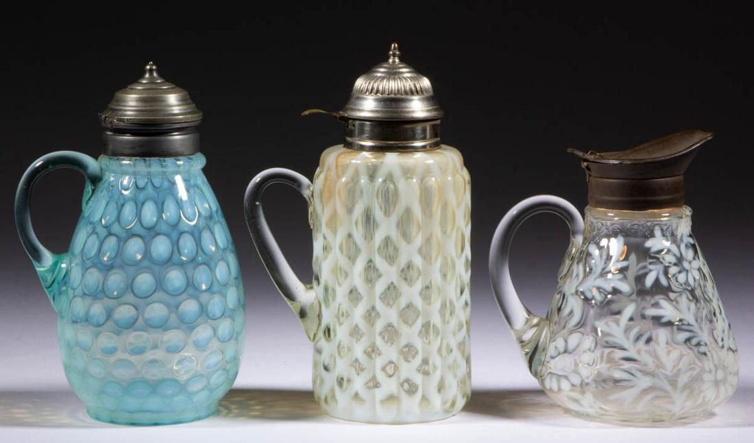 ASSORTED OPALESCENT GLASS SYRUP PITCHERS, LOT OF THREE: ASSORTED OPALESCENT GLASS SYRUP PITCHERS, LOT OF THREE, comprising a colorless opalescent Ribbed Opal Lattice, a colorless opalescent Daisy and Fern, and a blue opalescent Coinspot, each having a peri
