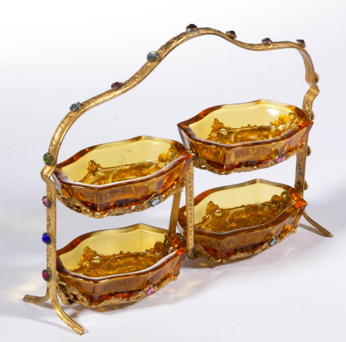 CZECH GLASS SET OF FOUR SALTS IN STAND: CZECH GLASS SET OF FOUR SALTS IN STAND, amber, four matching salts fitted into a gilt filigree handled frame with applied jewels, stamped "APOLLO/MADE IN U.S.A". Czech Republic. Circa 1930. Stand: 5 1