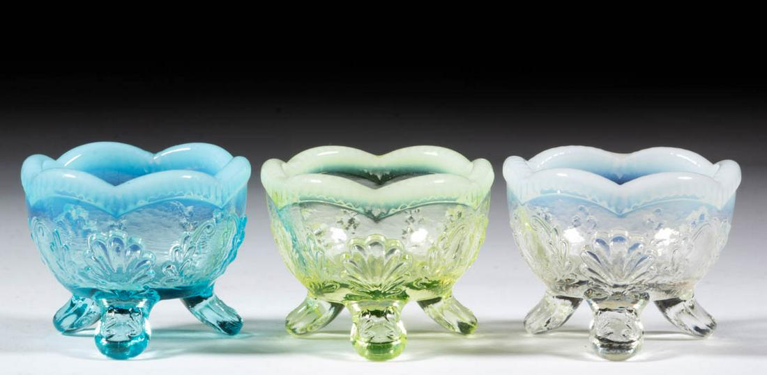 MANILA / WREATH AND SHELL INDIVIDUAL OPEN SALTS, LOT OF: MANILA / WREATH AND SHELL INDIVIDUAL OPEN SALTS, LOT OF THREE, colorless opalescent, blue opalescent, and Vaseline opalescent (reacts under black light), each raised on three feet. Model Flint Glass C