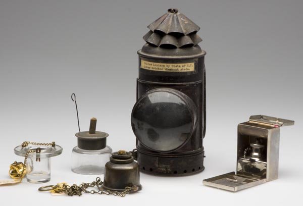 VARIOUS LIGHTING ARTICLES, LOT OF FIVE: VARIOUS LIGHTING ARTICLES, LOT OF FIVE, consisting of a colorless glass float lamp; a Dietz's policeman's lantern, two metal hanging whale oil lamps including one with chains, and a M. D. Pioneer trav
