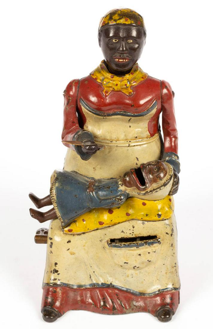 MAMMY WITH CHILD CAST-IRON MECHANICAL BANK: MAMMY WITH CHILD CAST-IRON MECHANICAL BANK, red dress, marked "PAT. APLD. FOR." to reverse. Working condition in original paint. Kyser & Rex, Frankford, PA. Circa 1884. 7 1/2" HOA, 4 1/2" DOA (base). 