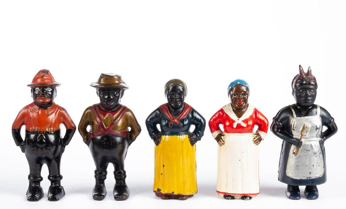 ASSORTED CAST-IRON BLACK AMERICANA PENNY / STILL BANKS,: ASSORTED CAST-IRON BLACK AMERICANA PENNY / STILL BANKS, LOT OF FIVE, including a Sharecropper, a Mammy with Spoon, and an Aunt Jemima (Mammy With Hands On Hips) in unusual coloration, each with likely