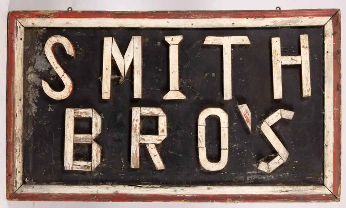 AMERICAN FOLK ART PAINTED WOOD AND TIN TRADE SIGN: AMERICAN FOLK ART PAINTED WOOD AND TIN TRADE SIGN, applied wooden letters "SMITH BRO'S" on a galvanized tin ground with applied molded-wood frame, retains original red-, white-, and blue-painted surfa
