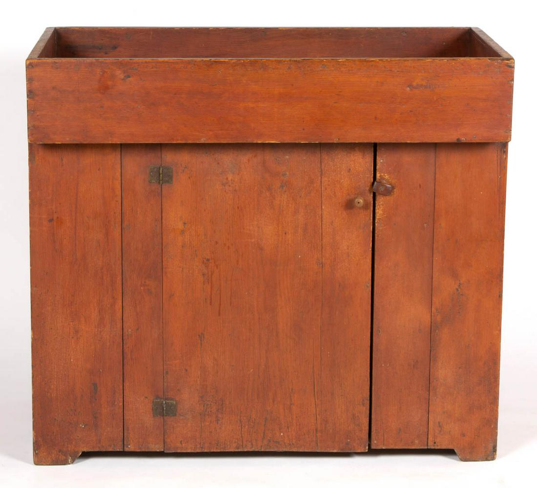 AMERICAN COUNTRY PINE DRY SINK: AMERICAN COUNTRY PINE DRY SINK, applied rectangular overhanging well, above one hinged door concealing two fixed shelves with later wooden knob, cut-out feet. Old surface with mellow color. 19th centu