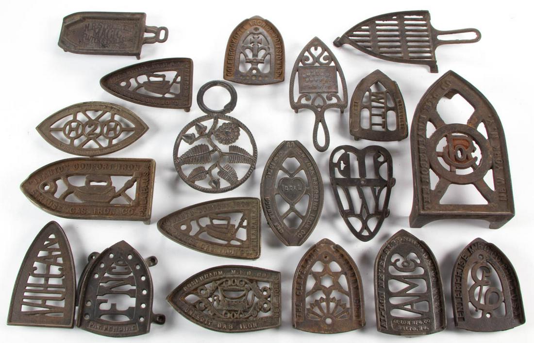 ASSORTED CAST-IRON TRIVETS, LOT OF 19: ASSORTED CAST-IRON TRIVETS, LOT OF 19, 16 examples with lettering or phases, including two The Rosenbaum Manufacturing Co., a New England Butt Co., an Al-Lon Manufacturing Co. Never Slip, a C. Gefrore